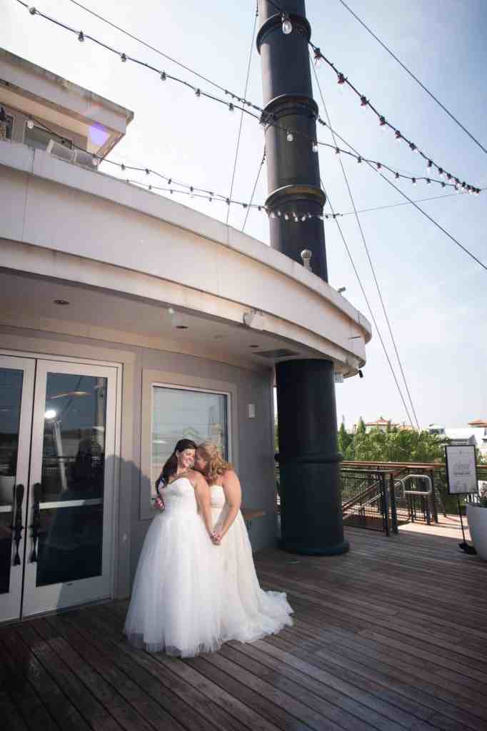 Two brides holding hands on Paddlefish's bow