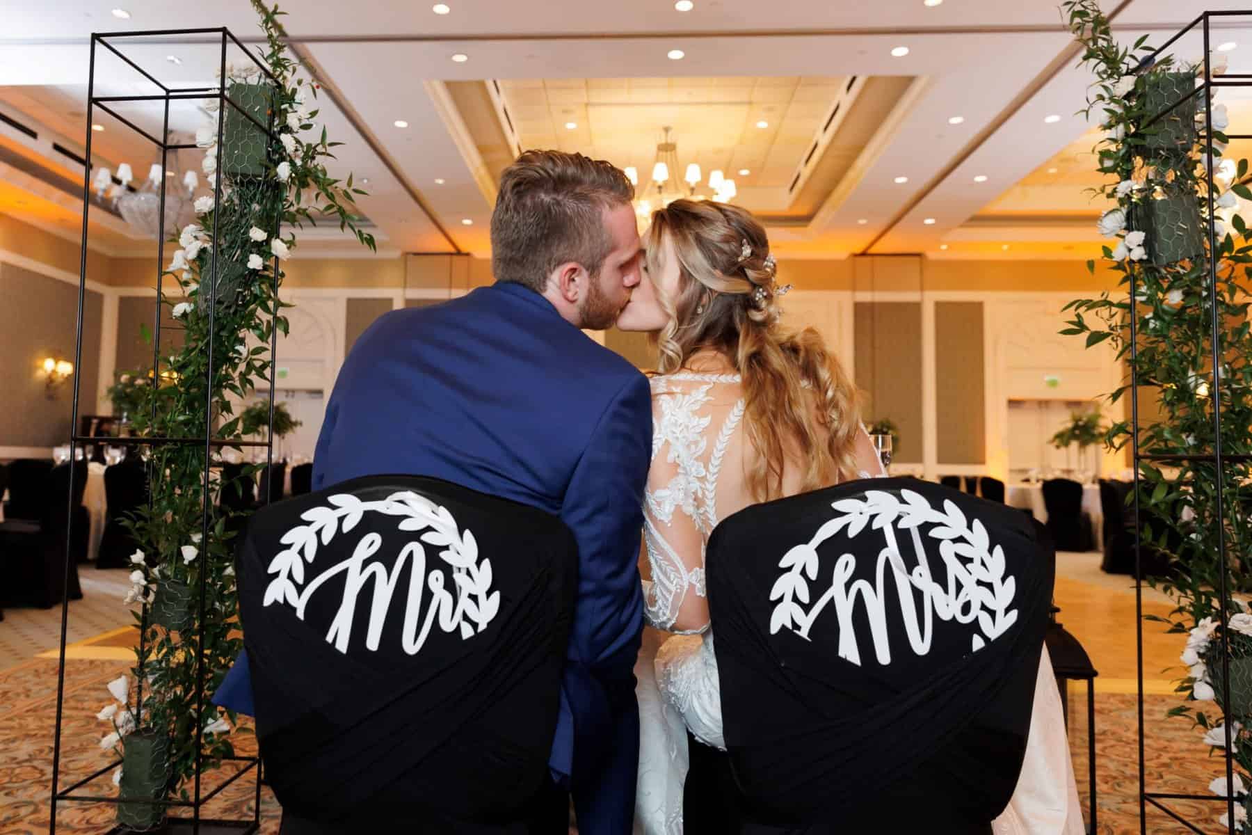 Bride and groom kissing at their sweetheart table