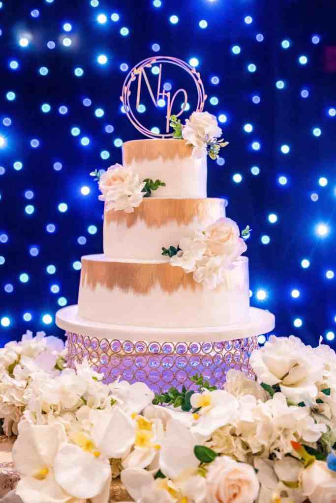 Three tiered white and gold wedding cake