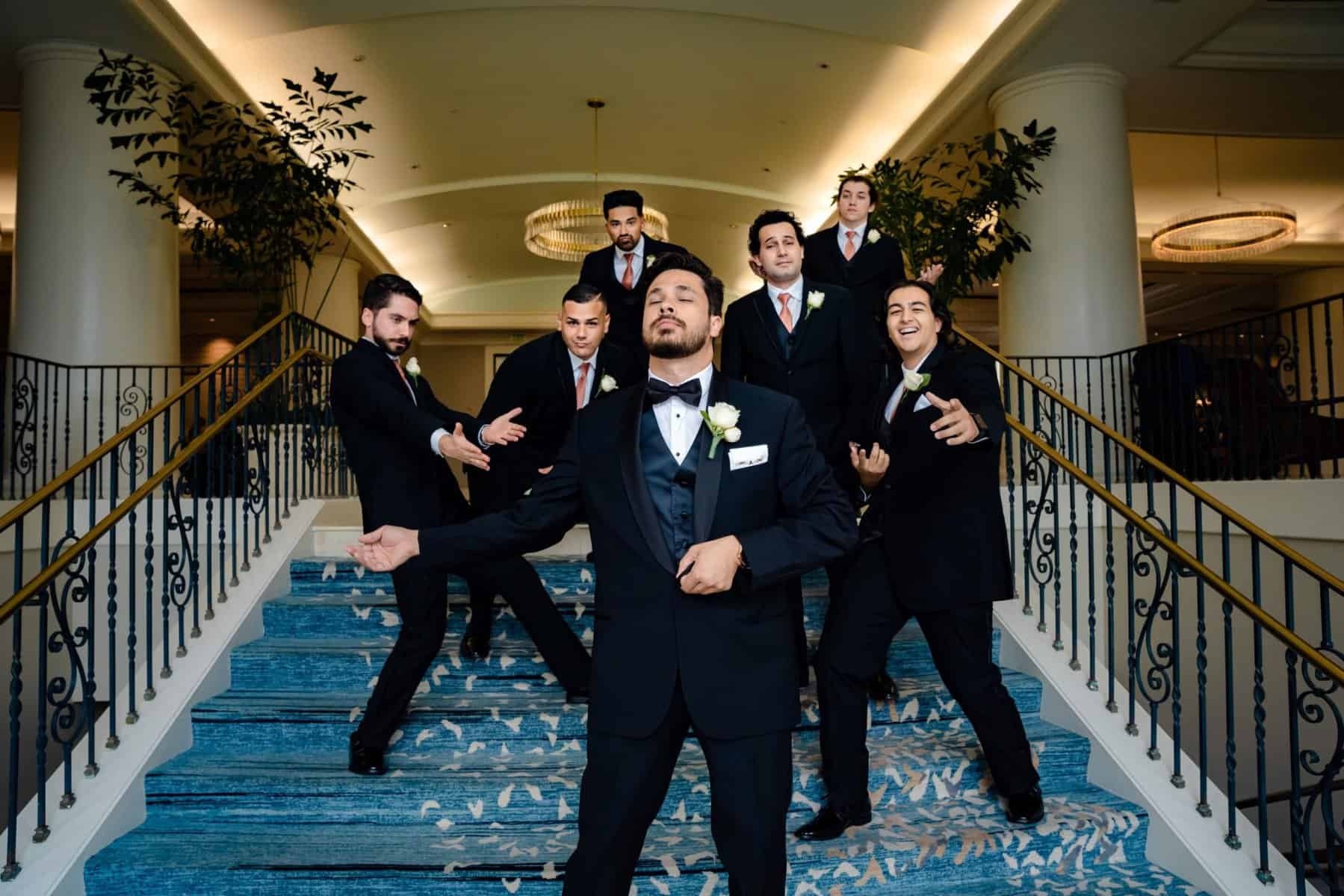 Groom posing with his groomsmen on stairs