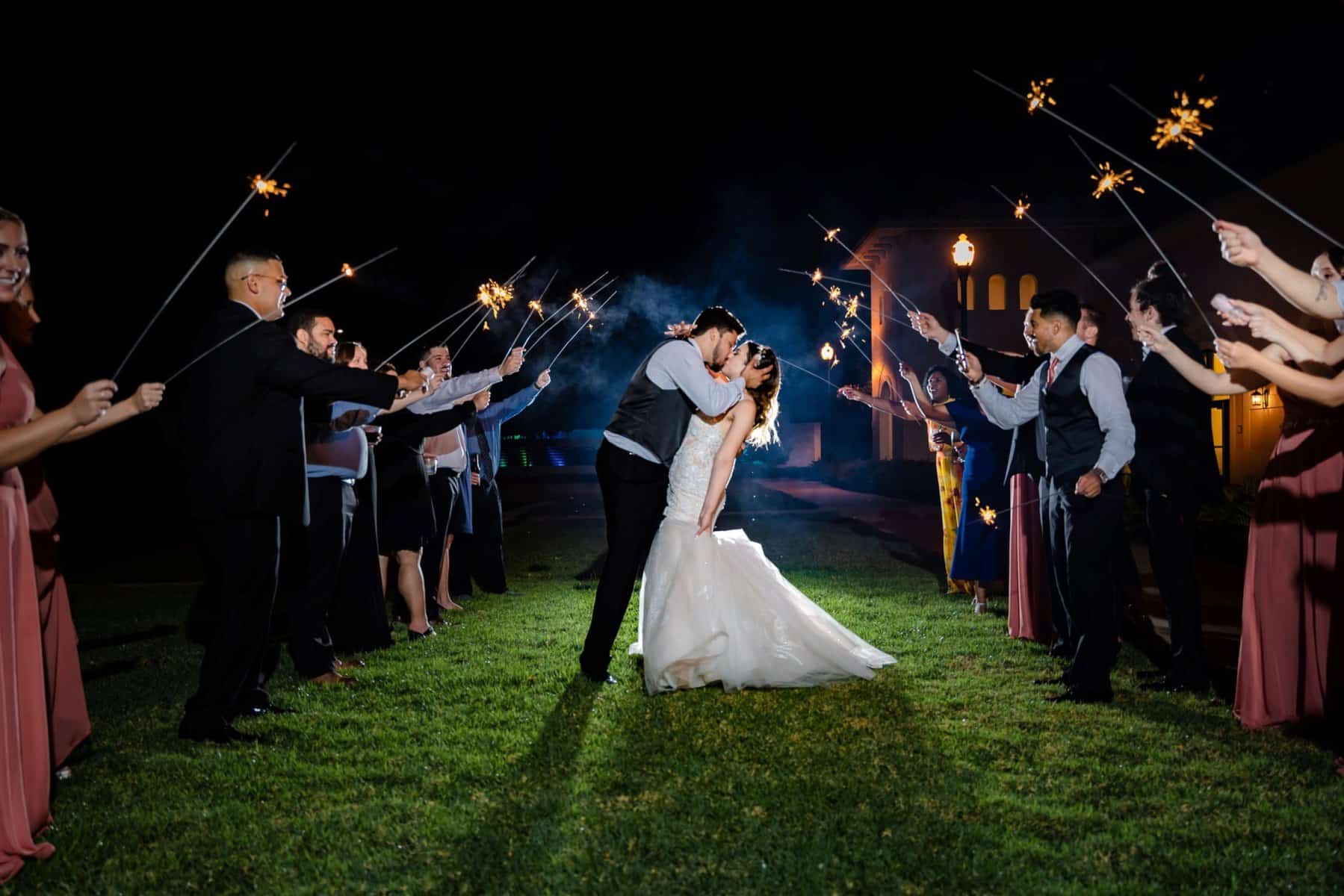 Bride and groom kissing during their sparkler exit