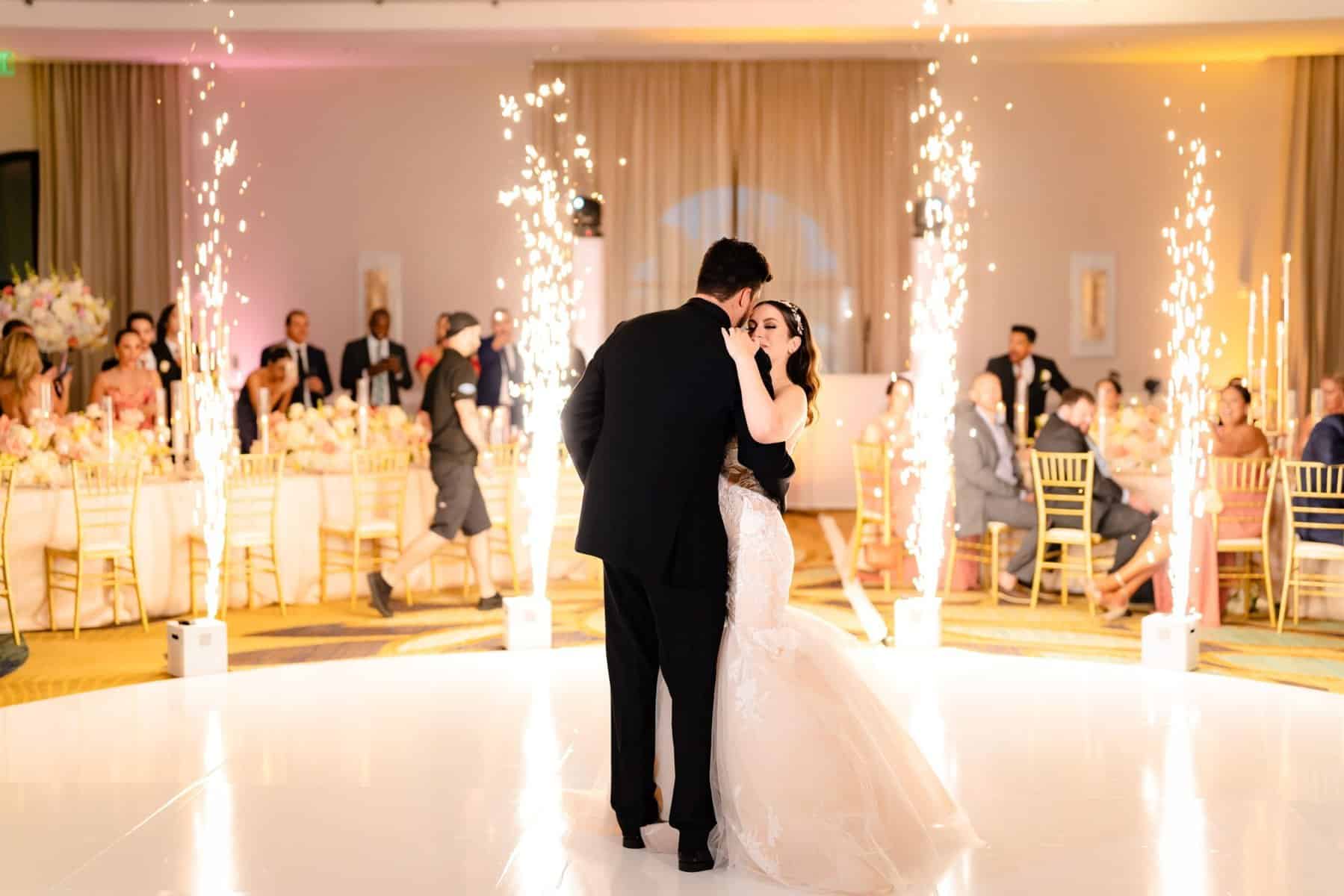 Bride and groom having their first dance with cold sparklers going off around them