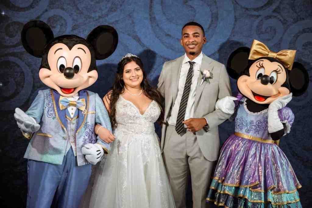 Bride and groom posing with Mickey and Minnie Mouse