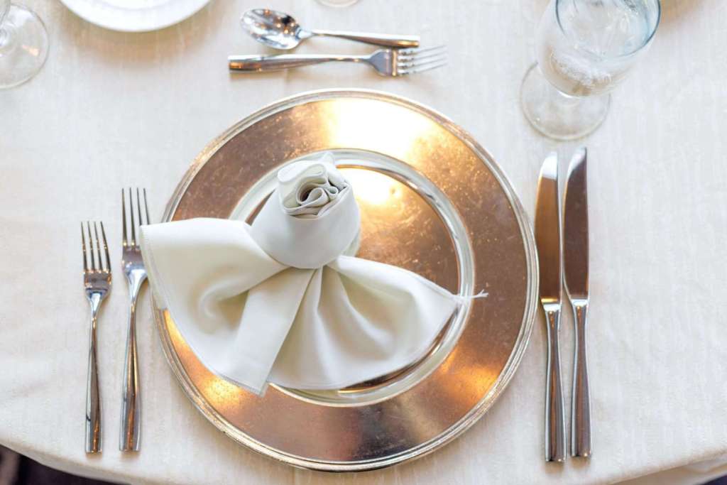 Silver charge plate with white linens