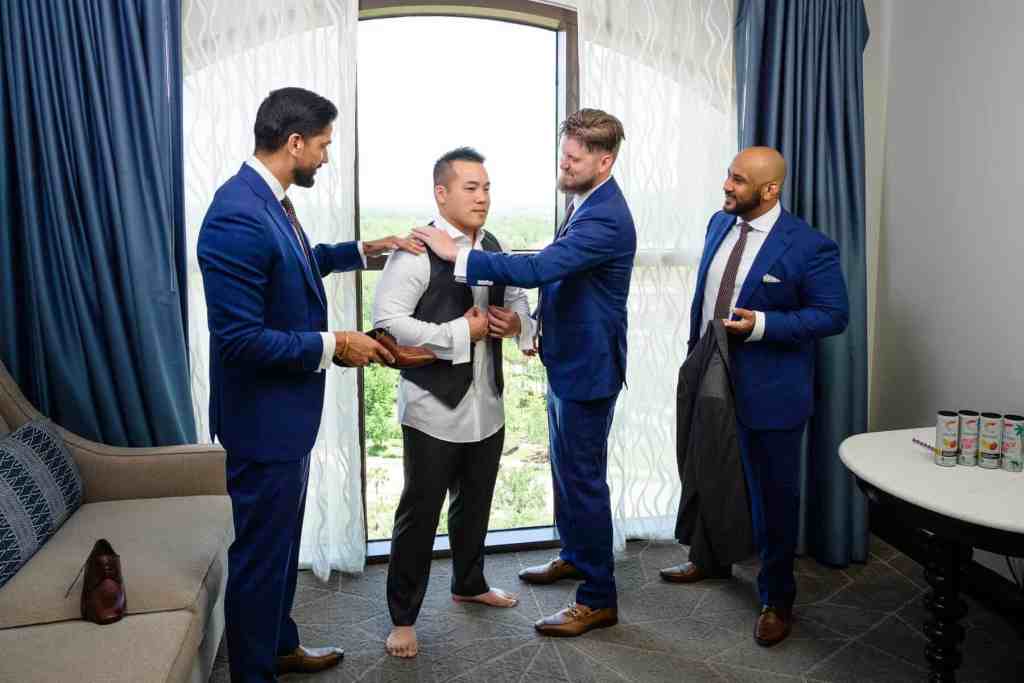 Groomsmen helping the groom get ready
