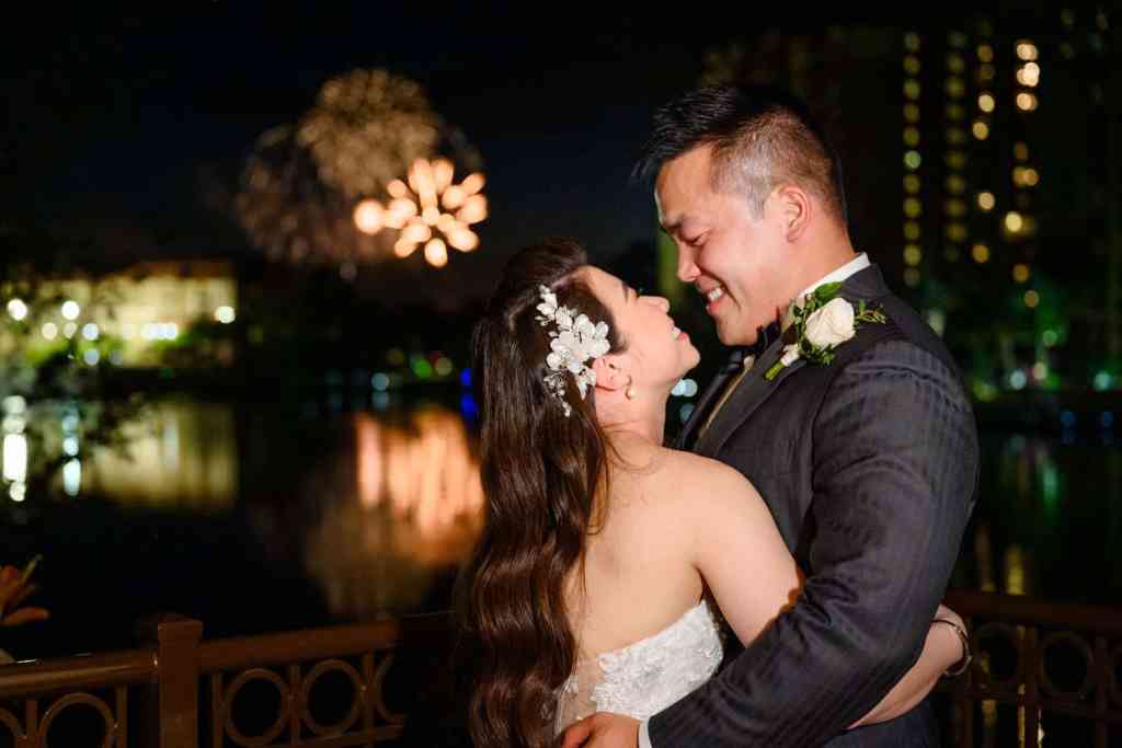 Bride and groom portraits around the Wyndham Grand Orlando Resort Bonnet Creek with fireworks in the distance