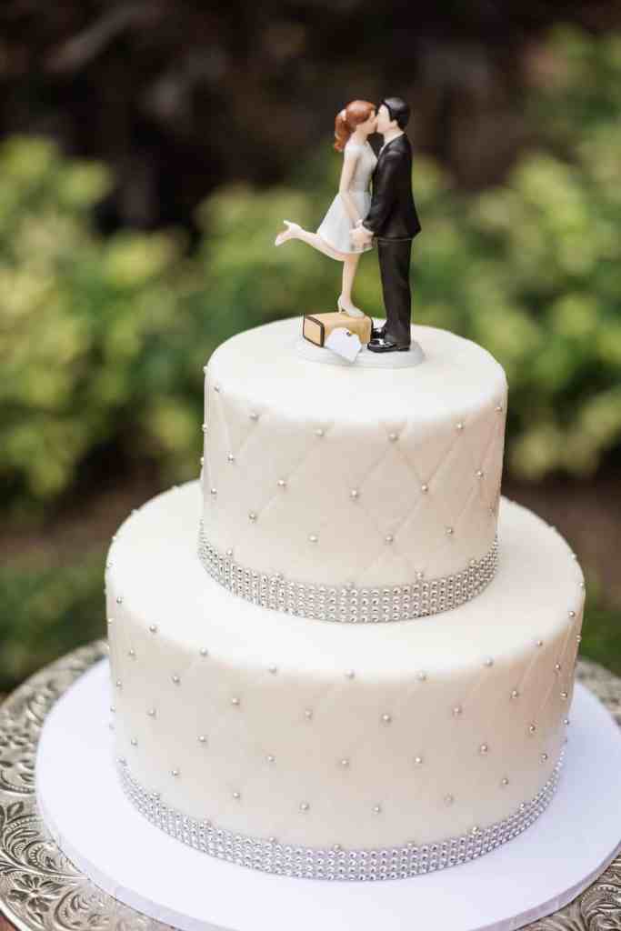 Two-tiered wedding cake with bride and groom topper