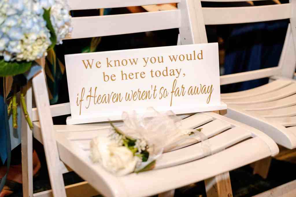 Memorial sign and a single white rose on a ceremony chair