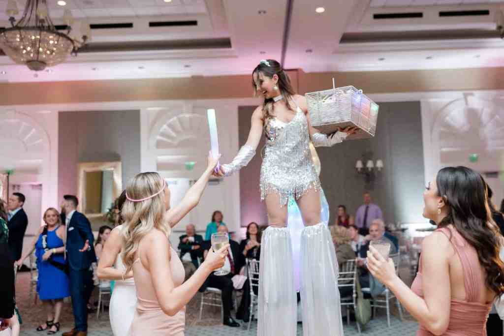 Stilt walker distributing glow sticks during the reception