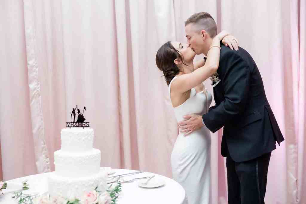 Bride and groom kissing after their cake cutting