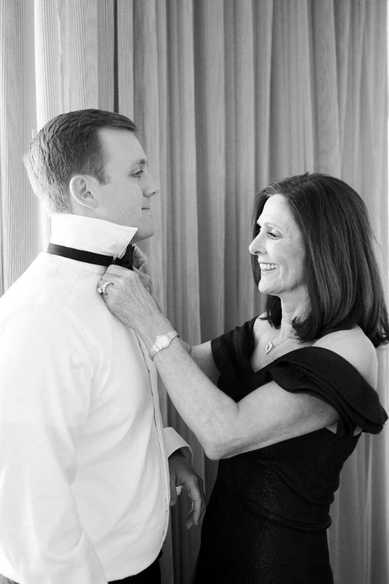 Mother of the groom helping her son tie his tie