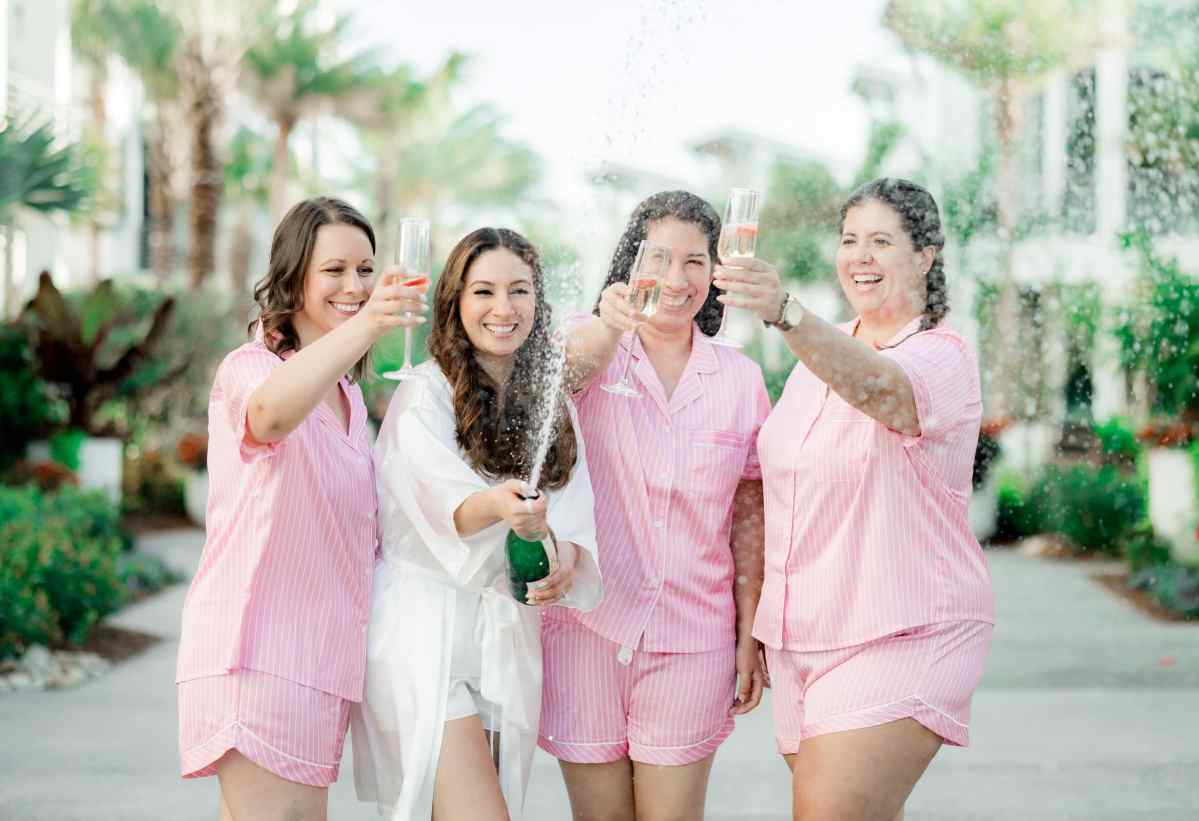 Bride and bridesmaids celebrating with champagne