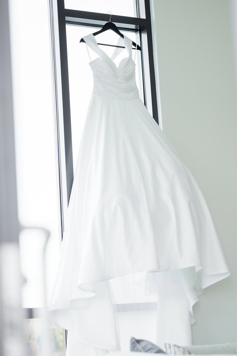 Wedding dress hanging in front of a window