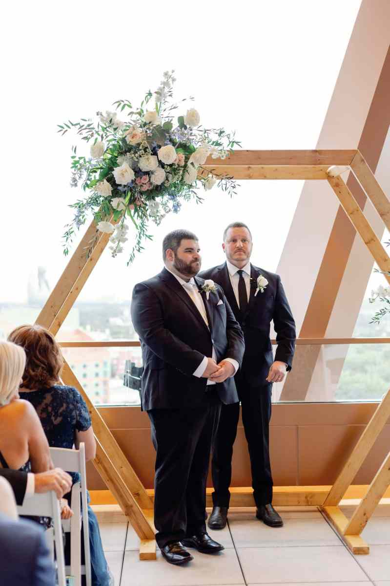 Groom watching his bride process