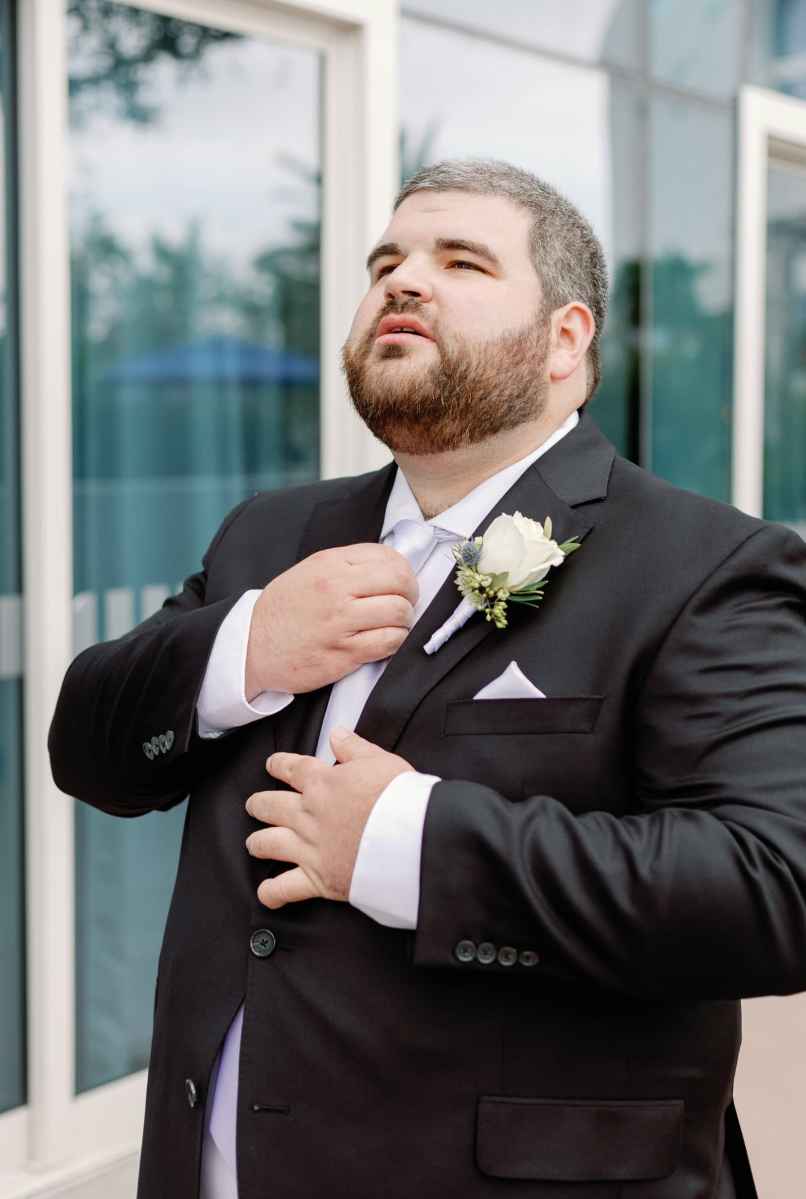 Groom straightening his tie