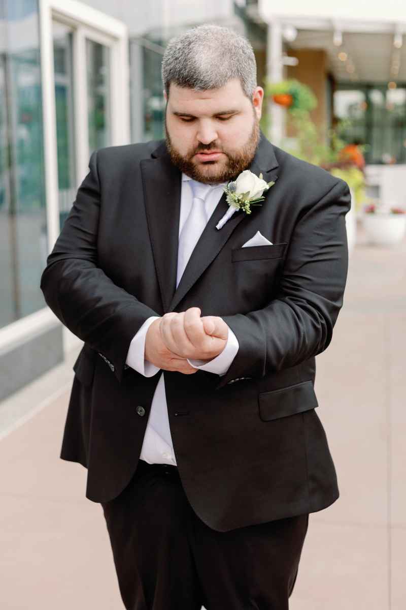 Groom adjusting his shirt sleeve