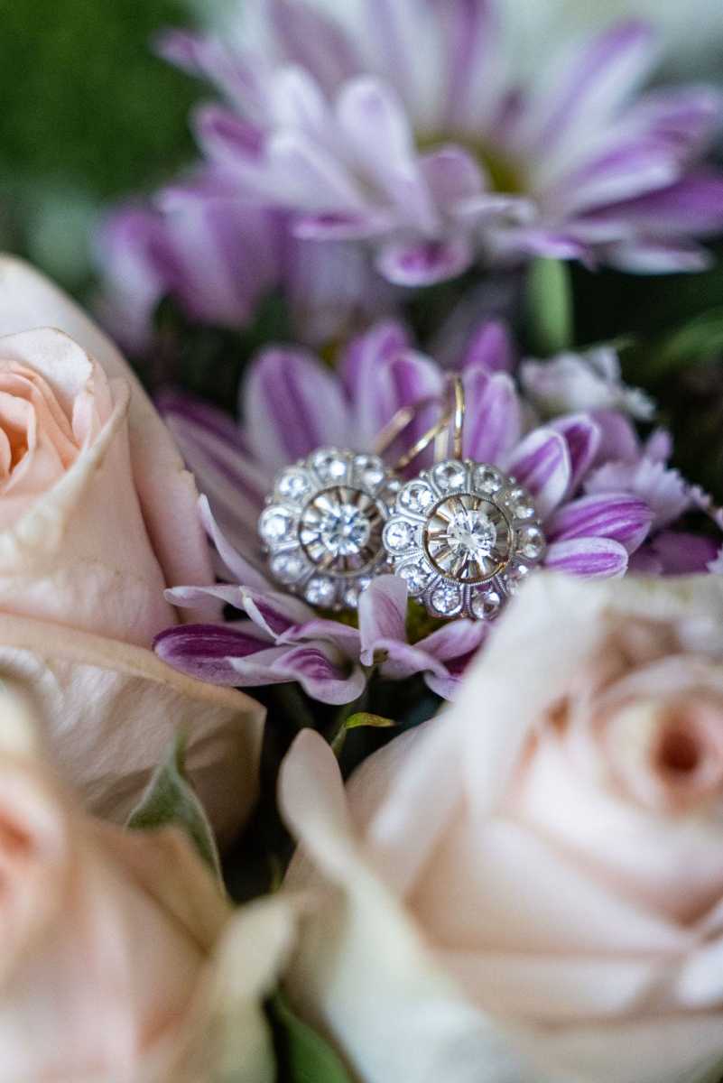 Bride's earrings against purple and blush floral