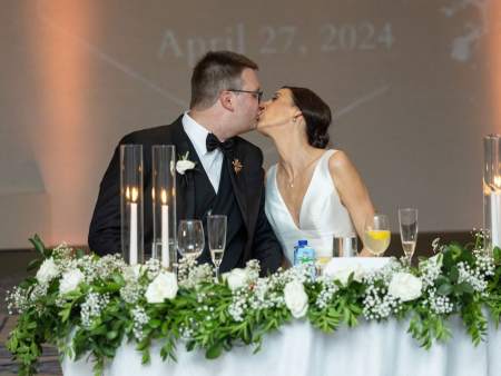 Bride and groom kissing at their sweetheart table