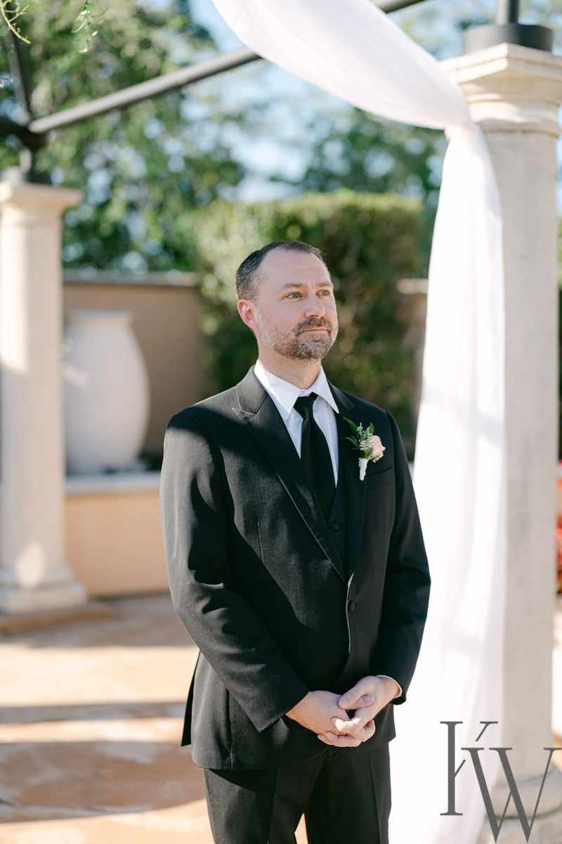 Groom watching his bride process up the aisle