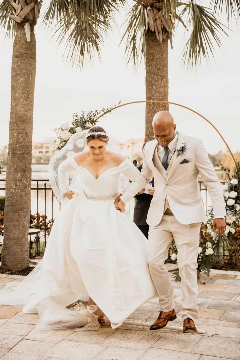 Bride and groom jumping the broom