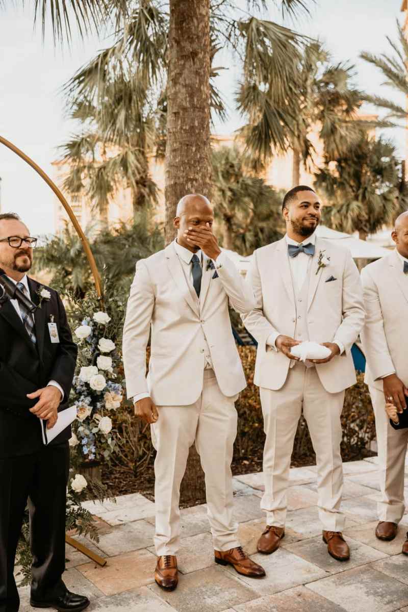 Emotional groom watching his bride walk up the aisle