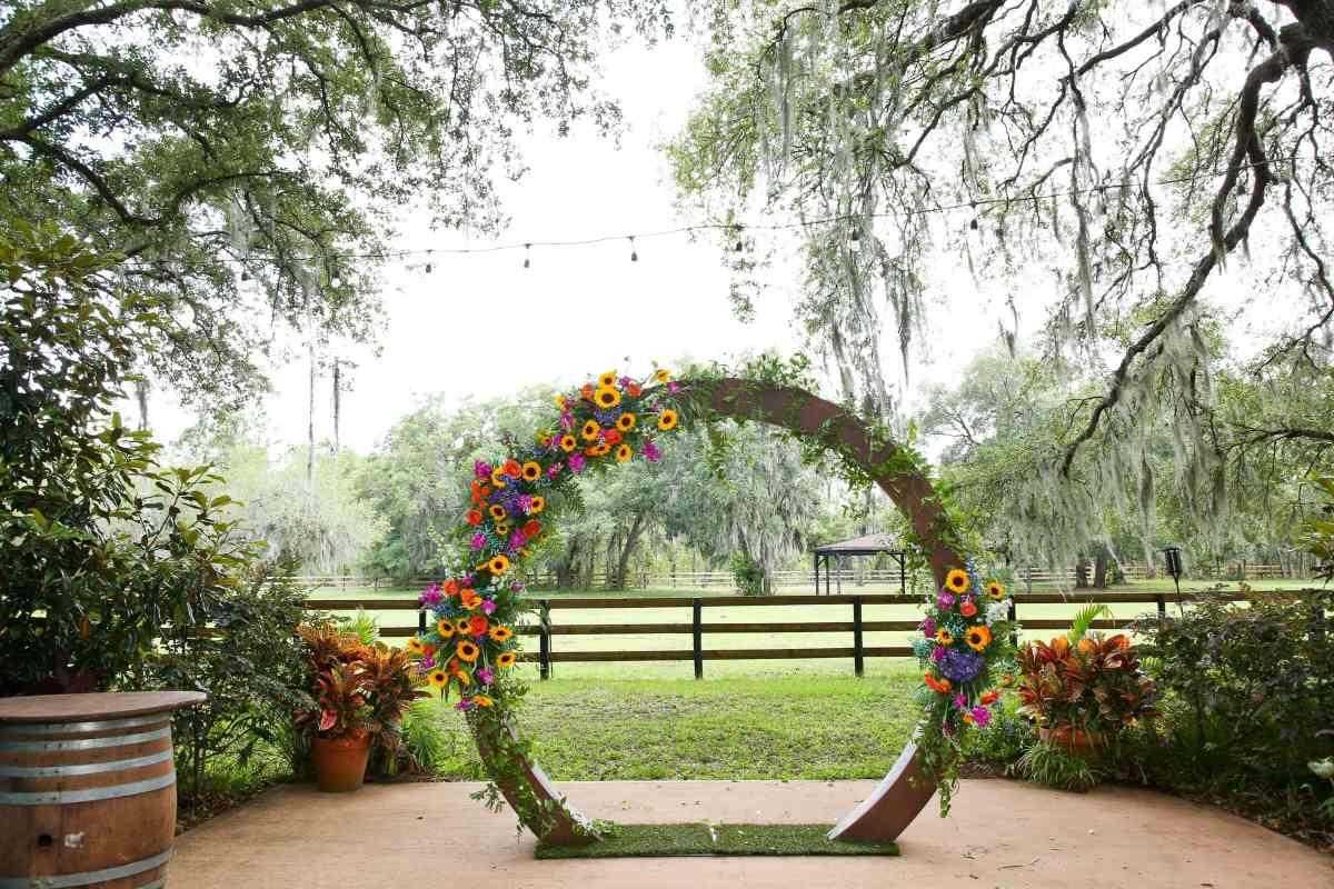 Circular ceremony arbor covered in colorful floral