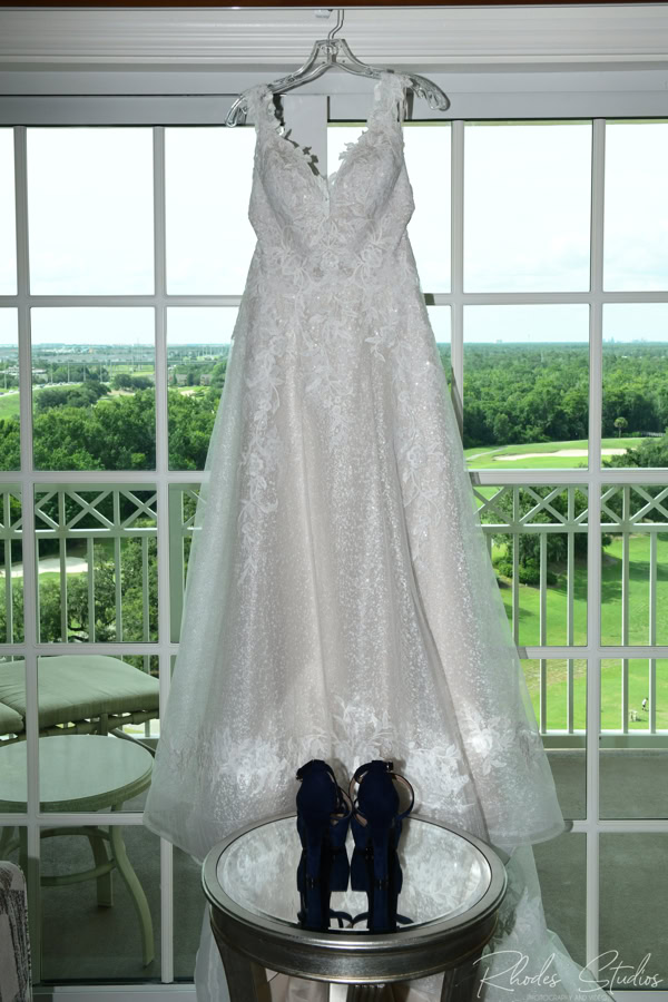 Wedding dress hanging in front of a window