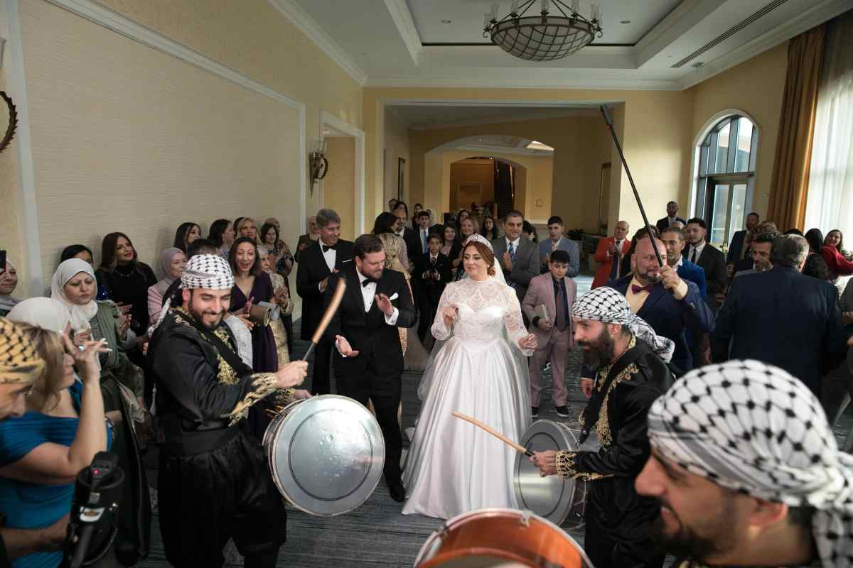 Bride and groom walking with their wedding guests in a traditional Zaffe