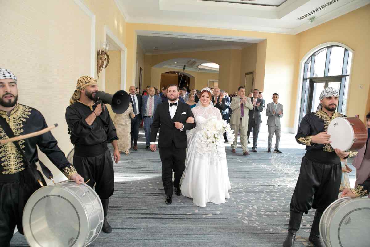 Bride and groom walking with their wedding guests in a traditional Zaffe