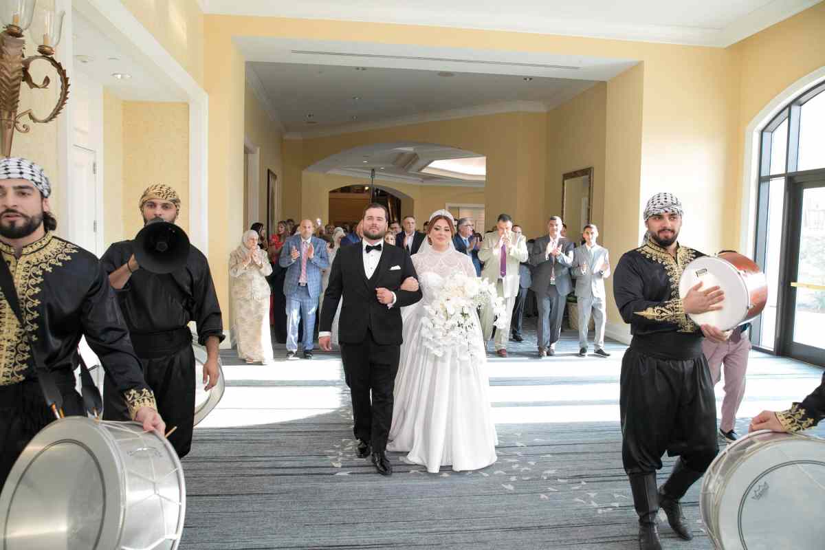 Bride and groom walking with their wedding guests in a traditional Zaffe
