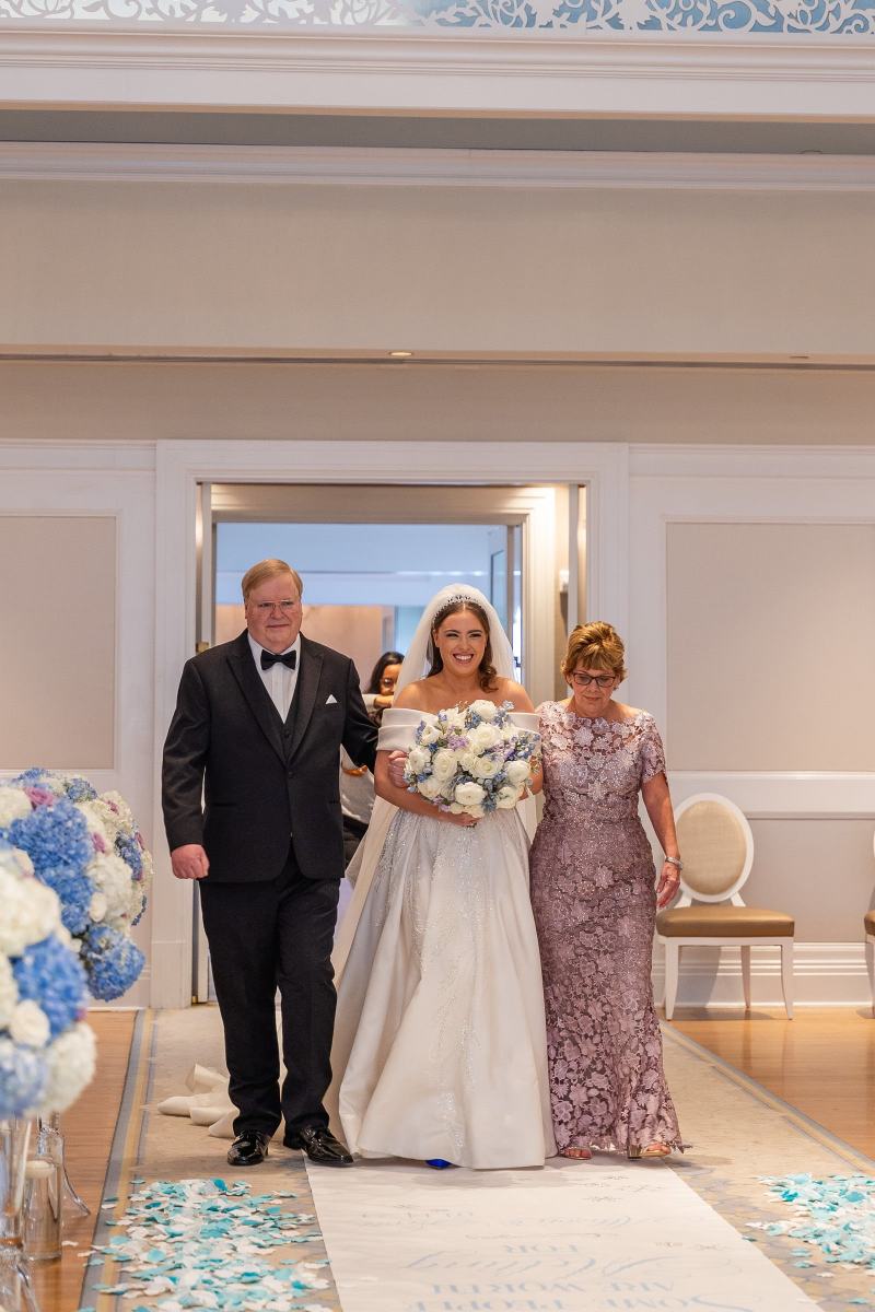Bride being escorted up the aisle by her parents