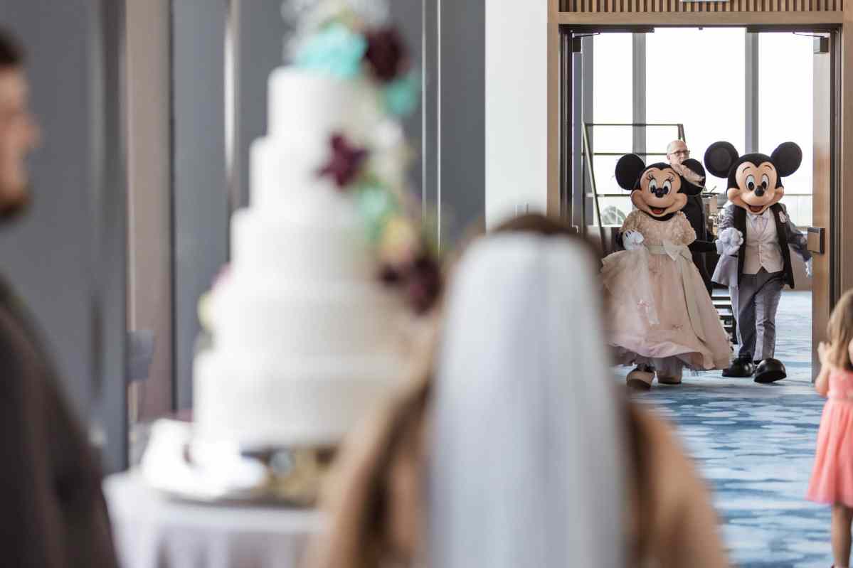 Bride and groom surprised by the arrival of Mickey and Minnie Mouse