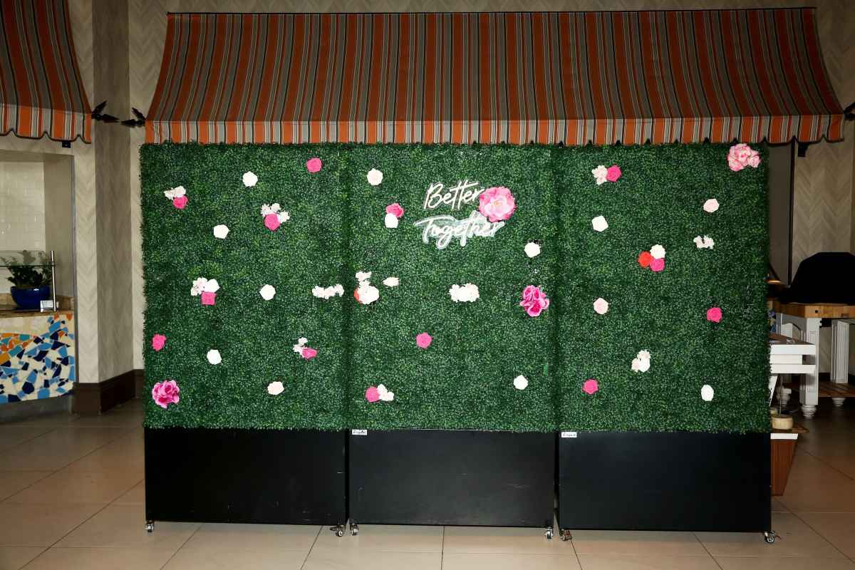 Hedge wall with a Better Together neon sign