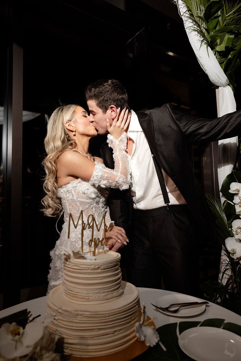 bride and groom kiss with cake